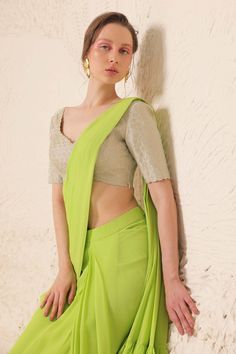 Lime green draped saree with placement rhinestone embellishment. Paired with a silver padded rhinestone embellished blouse.
Components: 2
Pattern: Blouse: Embellished
Type Of Work: Rhinestone
Neckline: V Neck
Sleeve Type: Half Sleeves
Fabric: Silk Georgette: Saree, Tissue: Blouse 
Color: Green
Other Details: 
Padded and scallop trim blouse
Attached inner lining
Length: (in inches)
Saree: 44
Blouse: 14
Pleat and ruffle detail pallu
Occasion: Sangeet - Aza Fashions Georgette Saree Blouse, Draped Saree, Drape Saree, Embellished Blouse, Scallop Trim, Pattern Blouse, Georgette Saree, Fabric Silk, Georgette Sarees