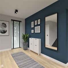 an empty room with blue walls and pictures on the wall, along with a rug