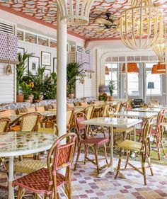 the inside of a restaurant with tables, chairs and chandeliers hanging from the ceiling