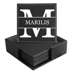 a stack of black and white coasters with the letter m on it's side