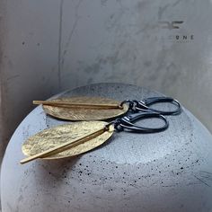 "Earrings made of silver and raw brass. The brass has a lightly textured and repoussed surface, allowing the leaves to reflect the light nicely, shining with the natural color of gold. The moving element subtly \"sounds\" when worn. Leverbacks earwires made of oxidized 925 silver. Length of the leaves is about 3 cm (about 1.18 inches). Length of earrings is ca. 5.5 cm ( approx. 2.16 inches).* It is possible to choose other earwires: hooks or studs (the last photo shows the available types of ear Minimalist Hand Forged Gold Earrings, Minimalist Hand Forged Bronze Earrings, Modern Gold Earrings With Oxidized Finish, Minimalist Hand-forged Gold Earrings, Gold Minimalist Earrings With Oxidized Finish, Minimalist Hammered Bronze Earrings, Modern Brass Earrings With Oxidized Finish, Minimalist Brass Earrings With Oxidized Finish, Handmade Brass Earrings With Nature-inspired Style