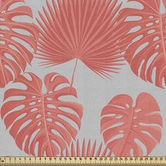 an orange and white tropical print fabric with large palm leaves on the side, in front of a ruler