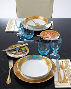 the table is set with gold and blue dishes