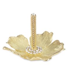 a gold brooch with crystal stones in the center and a flower on it's side