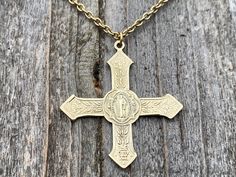 This is an antique replica of a gorgeous and very rare French Saint Benedict Cross Medal from the end of the 19th Century. The oxidized (antiqued) solid gold bronze allows the beautiful details to radiate making it more beautiful than my original from France. This cross is a bit more on the feminine side since it is lightweight and adorned with flowers and foliage. The cross measures 1.3 inches. An antique gold 2x3mm cable chain complements the cross beautifully! This necklace is 20 inches long. St Benedict Cross, Cross Medal, Bronze Gifts, Saint Benedict, Necklace Antique, Confirmation Gifts, Gold Cross, Sacred Heart, The Cross