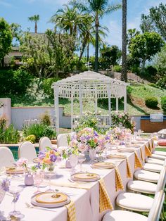 an outdoor dining area with white tables and yellow checkered tablecloths on it