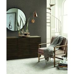 a living room scene with focus on the arm chair and sideboard in the foreground