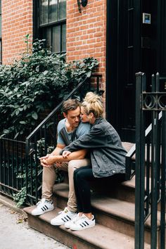 a man and woman sitting on steps next to each other