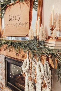 a fireplace mantel decorated for christmas with stockings, candles and pine cones on it