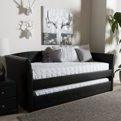 a living room with a black couch and white pillows