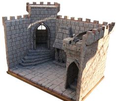 a model of a castle made out of bricks and stone blocks with stairs leading up to the entrance