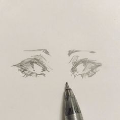 a pen is laying on top of a piece of paper next to a drawing of an eye