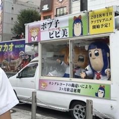 a man standing next to a food truck with stuffed animals in it's windows