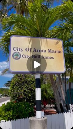 the city of ama marta sign in front of a white picket fence and palm trees