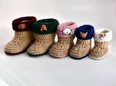 four crocheted booties are lined up on a white surface, one has a button and the other has a sheep