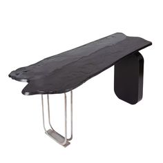 a black table with metal legs and a wooden bench on it's side, in front of a white background