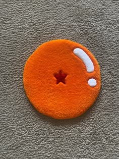 an orange and white cat toy with a star on it's side sitting on the floor