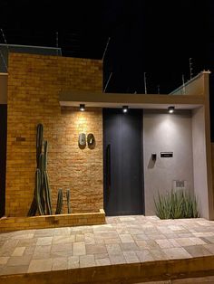 an entrance to a building with a cactus on the outside wall and lights above it