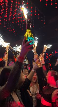 a group of people holding sparklers up in the air