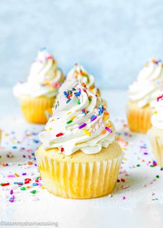 several cupcakes with white frosting and sprinkles