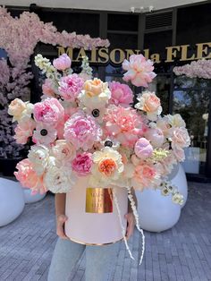 a woman holding a large bouquet of pink and white flowers