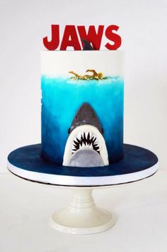 there is a cake with a shark on it and the words jaws written in red