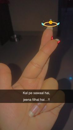 a woman's hand holding a tiny ring with an angel on it that says kal pe sawaa hai, jeena final hai