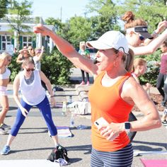 a group of women doing yoga outside in the sun with their arms stretched out and hands raised