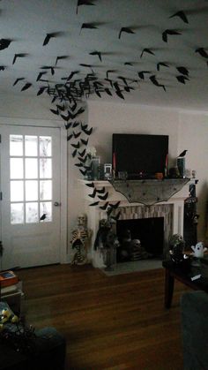 a living room filled with furniture and a fire place covered in birds flying over the fireplace