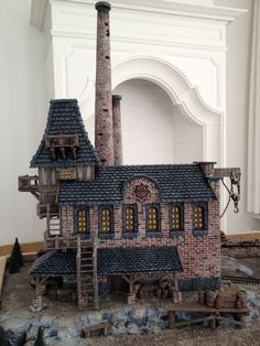 a toy house made out of lego bricks on a wooden floor next to a fireplace