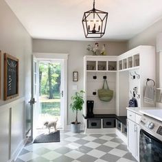 a kitchen with a checkered floor and lots of white cupboards on the wall