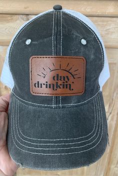 Distressed Trucker Hat with a front leather patch. Available in red, green or black. Images available Day Drinker, Beach Babe or Summer Vibes. Casual Trucker Hat With Leather Patch, Casual Black Trucker Hat With Leather Patch, Casual Hats With Leather Patch, Casual Hats With Leather Patch - One Size, Casual Distressed Brown Hat For Outdoor, Camping Hats, Hot Cocoa Party, Cocoa Party, Camping Hat