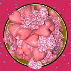 a bowl filled with pink and blue sprinkles on top of a table