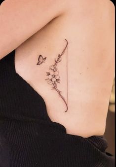 a woman with a butterfly tattoo on her left side shoulder and behind her back is a flower