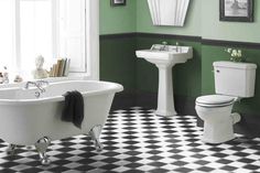 a bathroom with green walls and black and white checkered flooring on the floor