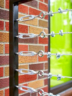 a close up of a window with metal bars on the outside and red brick wall behind it