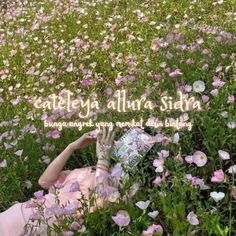 a woman laying in the middle of a field of flowers