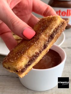 a person is dipping something into a small bowl with chocolate sauce in it and the words, nutella stuffed french toast sticks