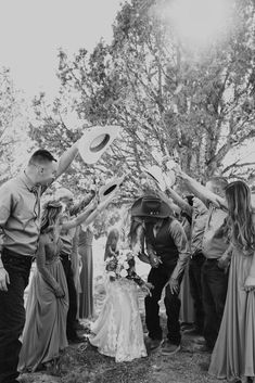 a group of people standing next to each other near a tree with a frisbee in the air