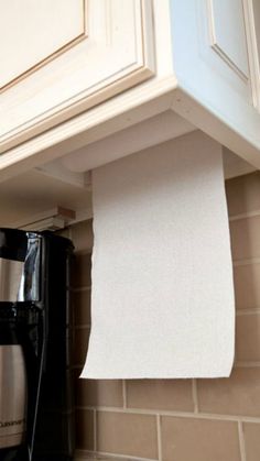 a coffee maker is sitting on the counter next to a paper towel dispenser