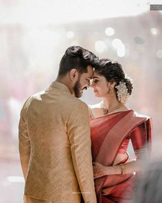 a man and woman standing next to each other in front of a window with lights