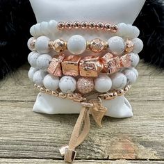 Boho Blush Bracelet Stack – where the enchanting hues of rose gold and pristine white hues come together in a whimsical dance of elegance and boho charm. This stack isn't just jewelry; it's a serenade to your free-spirited soul. Treat yourself with the Boho Blush Stack and let each bracelet tell a tale of carefree grace. So Pretty!! Wear them all on one wrist and stack 'em up or wear 3 on one wrist and two on the other with a watch! Lead & Nickel Free Bracelets are 'one size fits most' and are designed to fit wrists up to 7.5" comfortably Stretch bracelets set of 5 Off White and Rose Gold Hues Pave Crystal Embellishment Heart Charm with Leather Fringe Pull Please be aware that due to the unique and handmade nature of each product, colors, shapes, and bead sizes may vary slightly from the p Feminine Adjustable White Jewelry, Feminine White Adjustable Jewelry, Bohemian Rose Gold Jewelry For Party, Adjustable Spiritual Rose Gold Jewelry, Rose Gold Beaded Bracelet Jewelry, Adjustable Feminine Rose Gold Bracelets, Bohemian White Charm Bracelet With Round Beads, Bohemian Charm Bracelet With White Round Beads, Adjustable Rose Gold Charm Bracelet For Parties