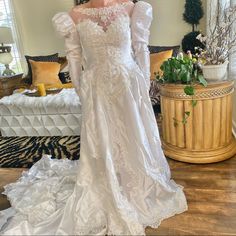 a woman in a white wedding dress standing on a wooden floor