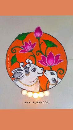 an orange plate with two sheep on it and flowers painted on the side, surrounded by candles