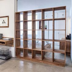 a wooden book shelf sitting in the middle of a room