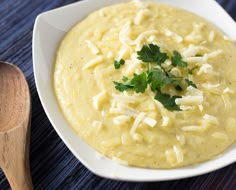 a white bowl filled with mashed potatoes and garnished with parsley