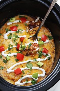 a crock pot filled with mexican food and garnished with cilantro