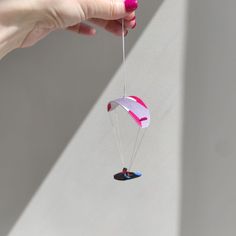 a hand holding a kite that is being held by another person's hand with the string attached to it