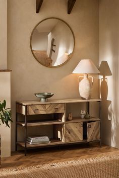 a living room scene with focus on the sideboard and table lamp, which has a round mirror above it