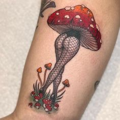 a woman's leg with a mushroom tattoo on her thigh and legs in fish net stockings